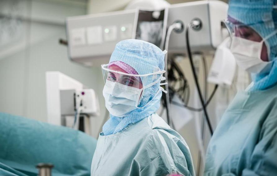 Female medical personnel in personal protective equipment in operating room